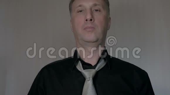 男人在领带上打结去上班黑色衬衫视频的预览图