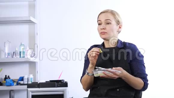 金发女孩在工作场所吃午饭快餐带午饭盒的理发师视频的预览图