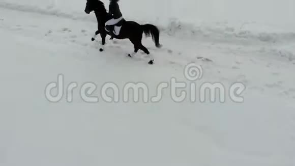一个年轻的女人骑着马在一个村庄的雪地上视频的预览图