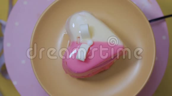 心在白色和粉红色的釉中的甜点在桌子上旋转视频的预览图