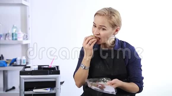 工作场所的快餐金发女人从饭盒里吃午饭视频的预览图