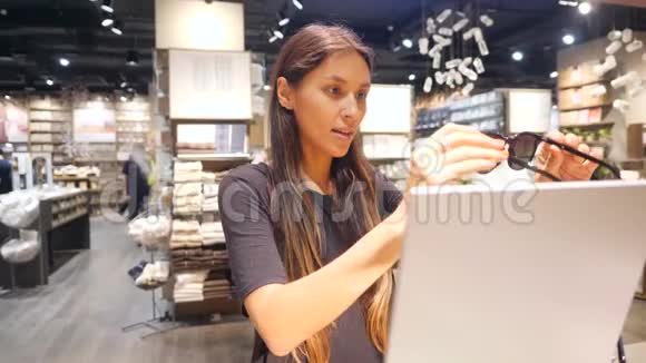 年轻美丽的混合种族希普斯特女孩尝试复古太阳镜在购物中心4K视频的预览图