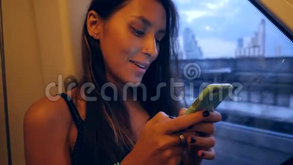 年轻迷人的混合种族妇女乘坐地铁列车和短信移动电话4K视频的预览图