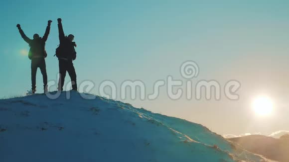 团队合作商务旅行理念2两个旅游者在山顶上两个登山者在冬天举起双手视频的预览图