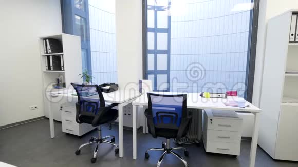 现代化优雅的办公室有全景窗和工作场所带有桌子椅子和箱子的轻型办公室内部视频的预览图