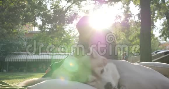 家庭和宠物年轻的母亲带着孩子躺在哈士奇狗附近背景是大自然的特写镜头视频的预览图