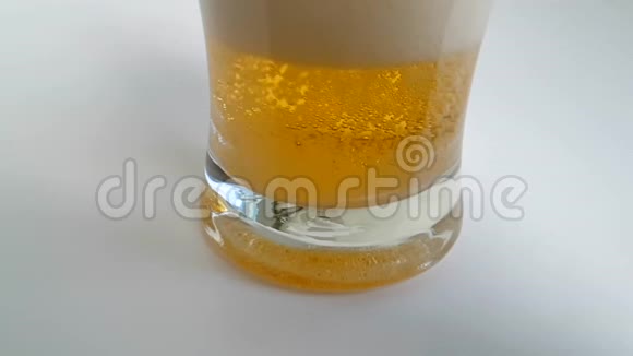 啤酒倒在白色背景上的玻璃杯里慢镜头视频的预览图