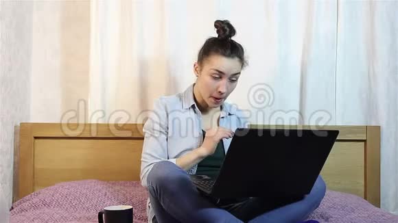一个年轻漂亮的女孩在笔记本电脑上工作时因疲劳而揉眼睛视频的预览图