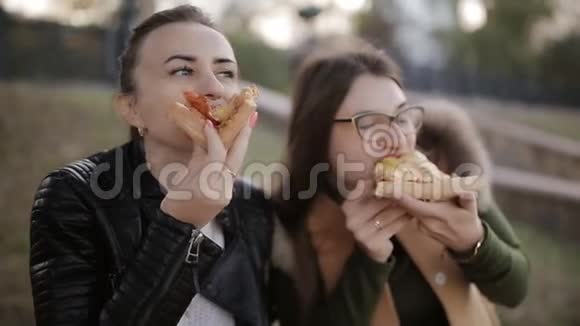 两个女人在城市的一个大盒子里吃一个大盒子里吃披萨视频的预览图
