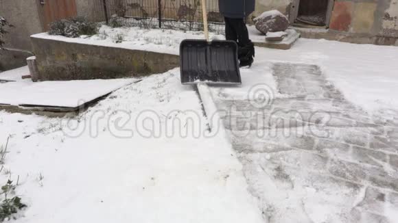 拿着雪铲的女人打扫院子的边缘视频的预览图