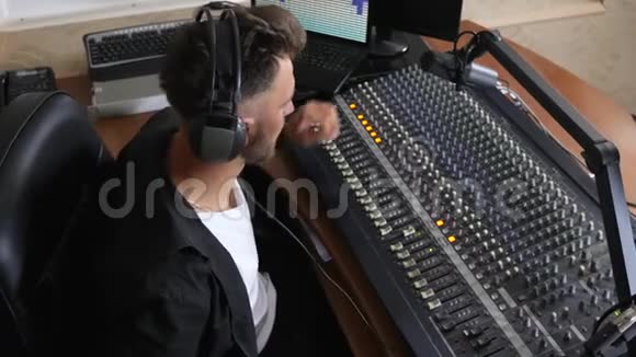 收音机主持人头戴耳机坐在椅子上用麦克风讲话视频的预览图