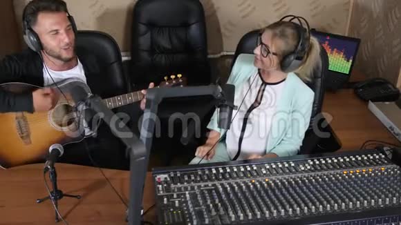 在电台采访中男人会弹吉他坐在幸福的女人身边视频的预览图