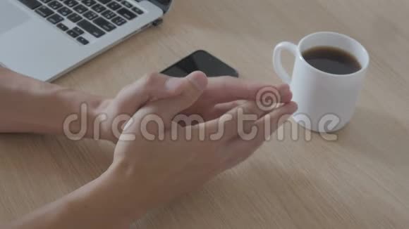 在办公室里的电脑上工作后一个人捏着手指的特写镜头手指体操视频的预览图