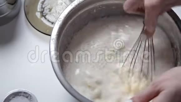 厨房里的女孩在银碗里摇着烘焙所需的原料烹饪和烘焙的概念视频的预览图