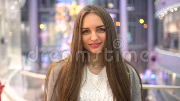 年轻女人看着相机微笑的肖像在商场购物的女人购物消费主义概念特写视频的预览图