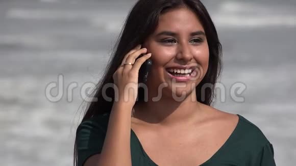 快乐的西班牙裔青少年或年轻女子在手机上交谈视频的预览图