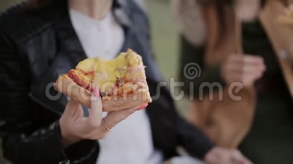 两个女人在城市的一个大盒子里吃一个大盒子里吃披萨视频的预览图