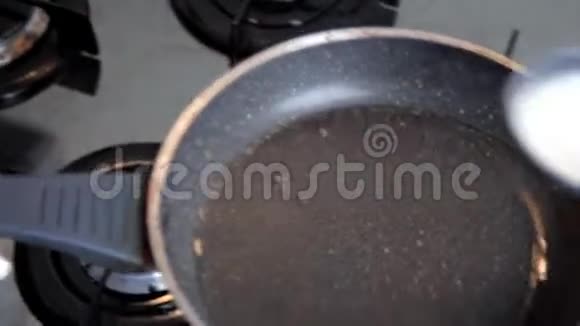 在煎薄饼时在热锅上倒入液体面团视频的预览图