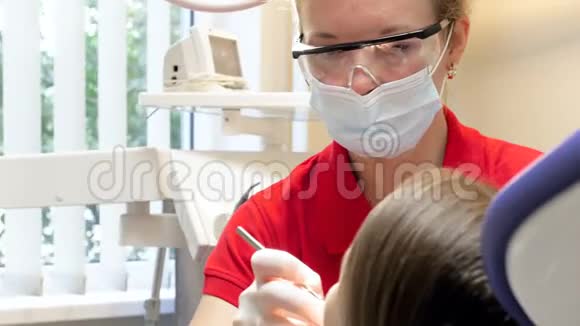 4k段女牙医治疗坐在牙科椅上的少女视频的预览图