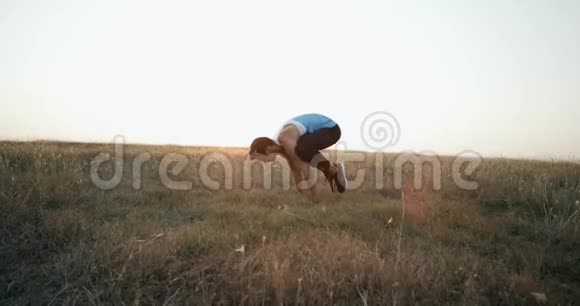 年轻的运动男子练习倒立瑜伽姿势的自然在户外做瑜伽动作和姿势的白人视频的预览图