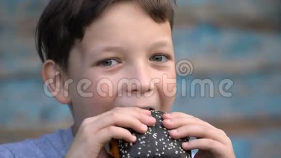 男孩吃黑色汉堡视频的预览图