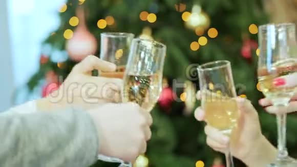 公司正拿着带有香槟和克林克的眼镜背景上是圣诞树圣诞节庆祝活动视频的预览图