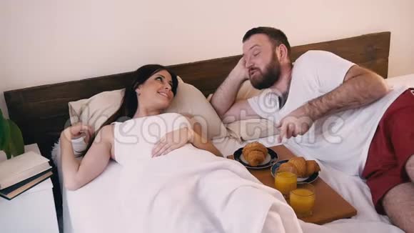 早晨卧室里的男人叫醒了他妻子在床上吃早餐视频的预览图
