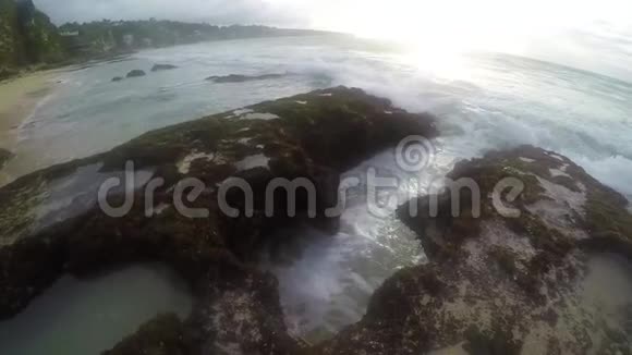 海滩上的一个小型海洋喷泉水被吸收并缓慢地向四面八方喷射视频的预览图