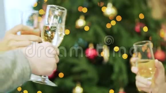 公司正拿着带有香槟和克林克的眼镜背景上是圣诞树圣诞节庆祝活动视频的预览图