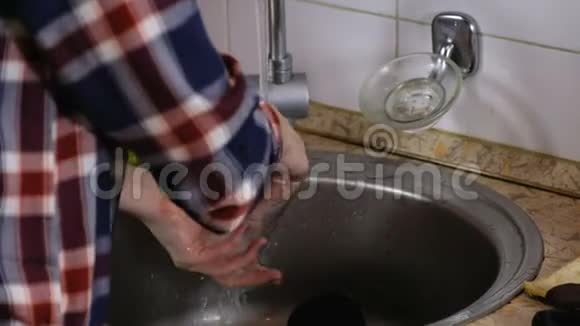 女人穿着格子衬衫在厨房洗玻璃杯它检查干净视频的预览图