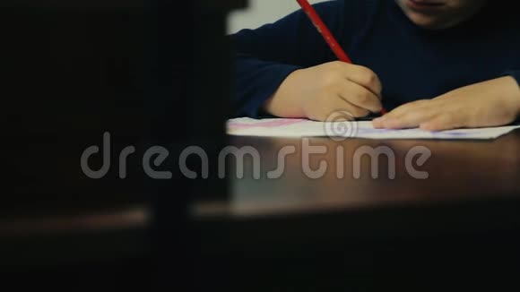 小男孩正在桌旁写字视频的预览图