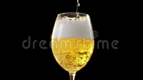 金色泡沫啤酒慢慢倒入玻璃杯黑色背景下的啤酒杯啤酒中的气泡淡啤酒视频的预览图