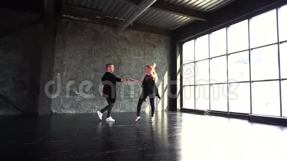 专业舞者在工作室跳舞一对舞者在一扇大窗户的背景下翩翩起舞视频的预览图
