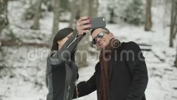 可爱的拉丁裔夫妇在雪地公园自拍视频的预览图