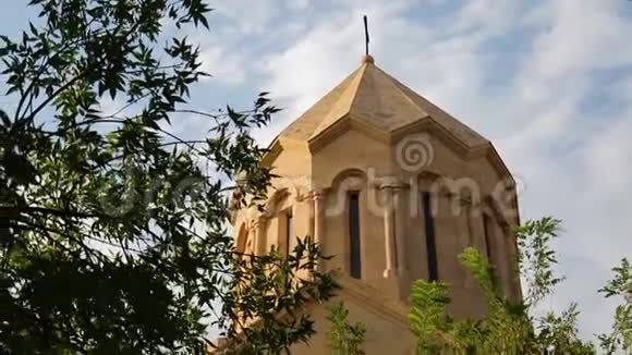 亚美尼亚天空背景上的砖砌教堂穹顶阳光透过树叶闪耀视频的预览图