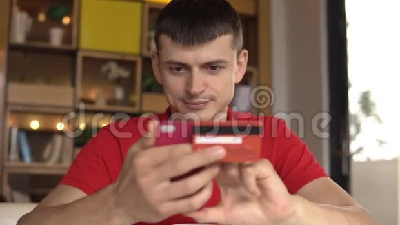 年轻人用他的信用卡在智能手机上从互联网上购买商品视频的预览图