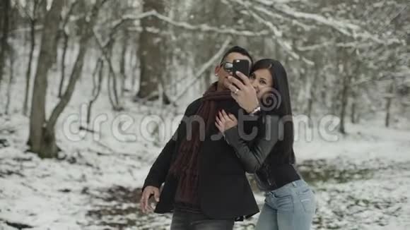 可爱的拉丁裔夫妇在雪地公园自拍视频的预览图