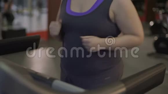 在跑步机上跑步时胖女人变成了苗条的运动型女士视频的预览图