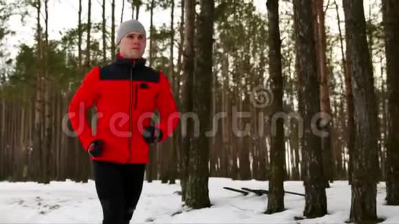 冬天一个穿着红色夹克的年轻运动员在新鲜空气中跑步视频的预览图