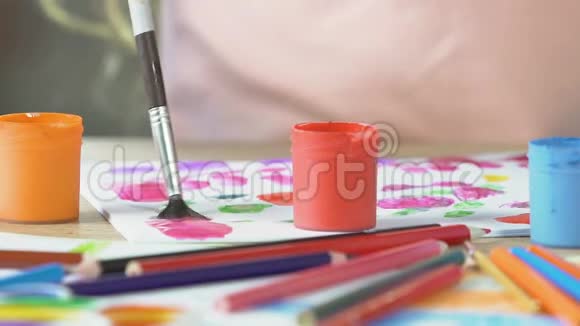 幼儿用画笔混合绘画色彩水粉颜料罐的特写艺术视频的预览图