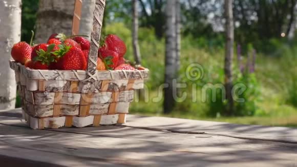 一篮子成熟的草莓落在木桌上视频的预览图