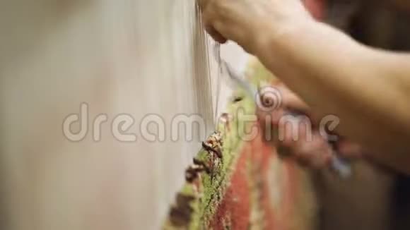 两名妇女用钩子编织手工地毯在亚美尼亚工厂工作视频的预览图