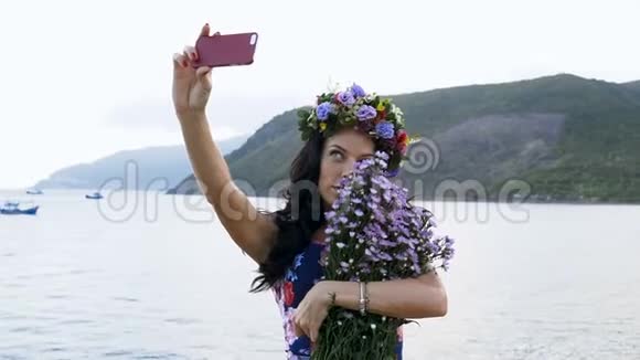 女孩在海上背景上用鲜花自画像视频的预览图