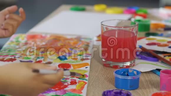 小孩子把所有可能的颜色混合在一张纸上想象力丰富视频的预览图