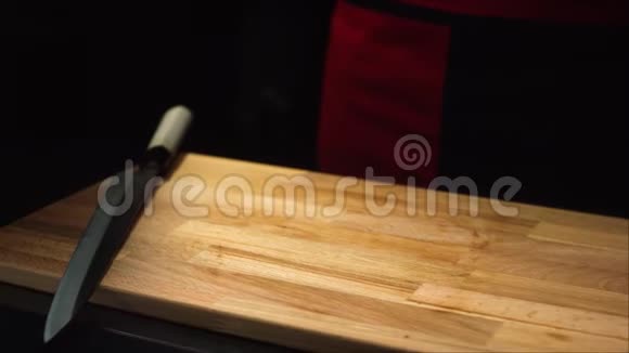 配红色三文鱼的特写厨师专业厨师穿着黑色围裙和手套把一块鲑鱼放在木板上视频的预览图