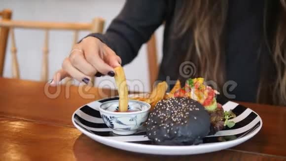 一位年轻的白人妇女在餐馆里吃着美味的炸薯条和番茄酱4公里视频的预览图