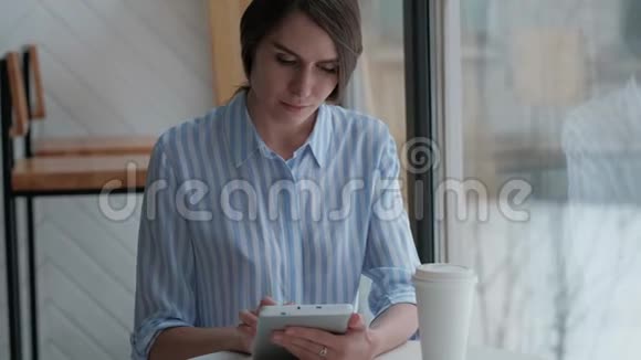 坐在自助餐厅用数码平板电脑的可爱女性视频的预览图