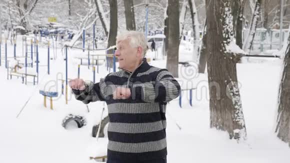 一位欧洲老年男子在冬天做一个早晨的户外热身锻炼背部健康生活视频的预览图