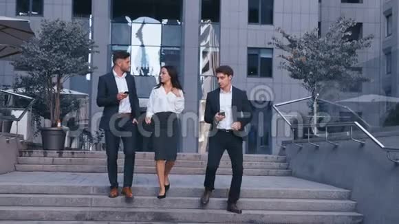 成功的商业人士在中央商务区讨论商业和步行两名青年男子和一名女子视频的预览图