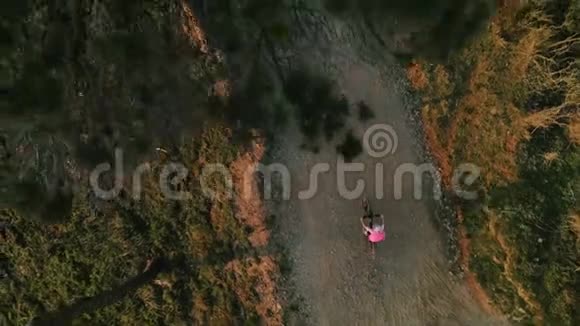 日落时分骑自行车的女子无人机镜头视频的预览图